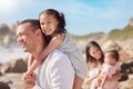 A happy mixed race family of four enjoying fresh air at the beach. Hispanic couple bonding with their daughters while Royalty Free Stock Photo