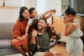 A happy mixed race family of four relaxing in the lounge and being playful together. Loving black family bonding with Royalty Free Stock Photo