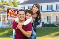 Happy Mixed Race Family In Front of House and Sold For Sale Real Estate Sign Royalty Free Stock Photo