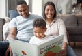 A happy mixed race family of three relaxing on the lounge floor and reading a story book at home. Loving black family Royalty Free Stock Photo