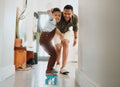 A happy mixed race family of two playing and skating on the lounge floor together. Loving black single parent bonding Royalty Free Stock Photo