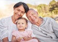 Happy mixed race grandparents sitting with granddaughter on a beach. Adorable, happy, hispanic baby girl bonding with Royalty Free Stock Photo