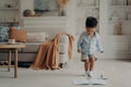 Happy mixed race little boy enjoying playing alone at home, having fun in living room Royalty Free Stock Photo