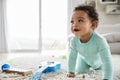 Happy mixed race toddler boy crawling in sitting room Royalty Free Stock Photo