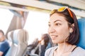 Mixed race woman passenger listening to the music or learning language while traveling in a train or bus