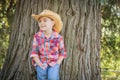 Happy Mixed Race Young Boy Wearing Cowboy Hat Standing Outdoors.