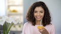 Happy mixed race young lady holding orange half, immune system protection, diet