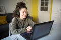 Happy mixed rase girl sits at computer screen laptop. student talks over Internet