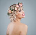 Happy model in flowers, portrait. Beautiful woman with short blonde curly hair and makeup on blue background Royalty Free Stock Photo