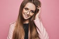 Happy model girl with amazing blue eyes and modish makeup in a leather jacket and trendy glasses, isolated at pink Royalty Free Stock Photo