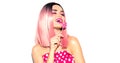 Happy model girl eating lollipop. Beauty Glamour young woman with trendy pink hair style and beautiful makeup Royalty Free Stock Photo