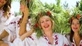 Happy models in floral circlets and ethnic clothing laughing outside in summer