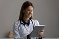 Happy modern day woman medic work at web on pad Royalty Free Stock Photo