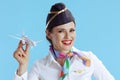 happy modern female air hostess on blue in uniform Royalty Free Stock Photo