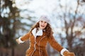 Happy modern female rejoicing outside in city park in winter