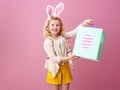 Happy modern girl isolated on pink with Easter shopping bag Royalty Free Stock Photo