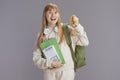 happy modern teen girl in beige tracksuit with backpack