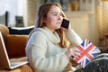 Teen girl with notebook colors of British flag using cell phone Royalty Free Stock Photo