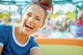 Happy modern traveller woman in theme park having ride