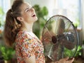 Happy modern woman enjoying fan blowing in face Royalty Free Stock Photo