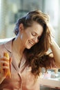 Happy modern woman holding hair oil bottle