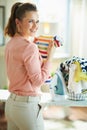 Happy modern woman with iron and clothes basket ready to iron Royalty Free Stock Photo