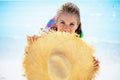 Happy modern woman hiding behind with big straw hat on seacoast Royalty Free Stock Photo