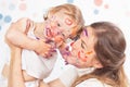 Happy mom and baby playing with painted face by paint Royalty Free Stock Photo