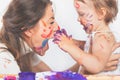 Happy mom and baby playing with painted face by paint Royalty Free Stock Photo