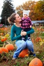 Happy Mom and Baby in pumpkin patch