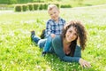 Happy mom and child chilling in public park garden in summer.smiling mother and son relaxing toghether outdoor laying on grass. Royalty Free Stock Photo
