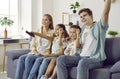 Happy mom, dad and children sitting on the sofa at home and watching television all together Royalty Free Stock Photo