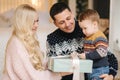 Happy mom, dad and little son give presents to each other. Enjoying love hugs, holidays people. Togetherness concept Royalty Free Stock Photo