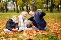 Happy mom, dad and son spending time and having fun together, taking selfie on the mobile phone at the autumn golden park Royalty Free Stock Photo