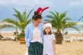 Happy mom and daughter child in Santa hat walking along beach Royalty Free Stock Photo