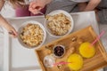 Happy mom and daughter have healthy breakfast on bed in a light bedroom on a sunny morning. Orange juice and oatmeal porridge with