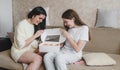 happy mom and daughter open a box of strawberries and wonder admiringly.