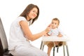 Happy mom feeding toddler boy with yogurt Royalty Free Stock Photo