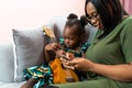 Happy Mom with her daughter playing guitar and singing together at home, happy family Royalty Free Stock Photo