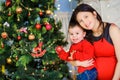 Happy mom with her little son decorate the Christmas tree Royalty Free Stock Photo