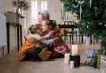 happy mom hugs her little daughters sitting on the floor near the Christmas tree. Royalty Free Stock Photo