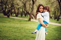 Happy mom hugs and kiss toddler kid son outdoor in spring or summer Royalty Free Stock Photo