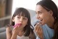 Happy mom and kid daughter having fun doing makeup together