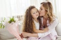 happy mom kissing her daughter and holding bouquet of flowers for happy Royalty Free Stock Photo