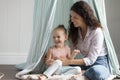 Happy mom playing with cute kid in toy tent Royalty Free Stock Photo