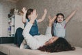 happy mom playing with her daughters lying on the couch clapping her hands Royalty Free Stock Photo