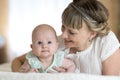 Happy mother playing and hug with newborn baby in bed Royalty Free Stock Photo