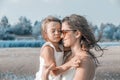 Happy mom plays with little daughter on the beach Royalty Free Stock Photo