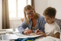 Happy mom and son doing homework and studying with laptop together. Home education Royalty Free Stock Photo