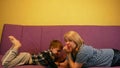 Happy mom and son are Europeans on the couch at home and enjoy using modern mobile devices. The